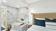 The luxurious and elegant master bathroom boasts a deep soaking tub,..