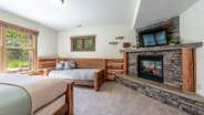 Downstairs king suite with additional twin bed, attached bathroom, and gas fireplace