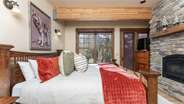 Primary suite on main level with fireplace, attached bathroom, and deck access