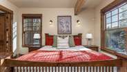 Primary suite on main level with fireplace, attached bathroom, and deck access