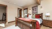 Primary suite on main level with fireplace, attached bathroom, and deck access